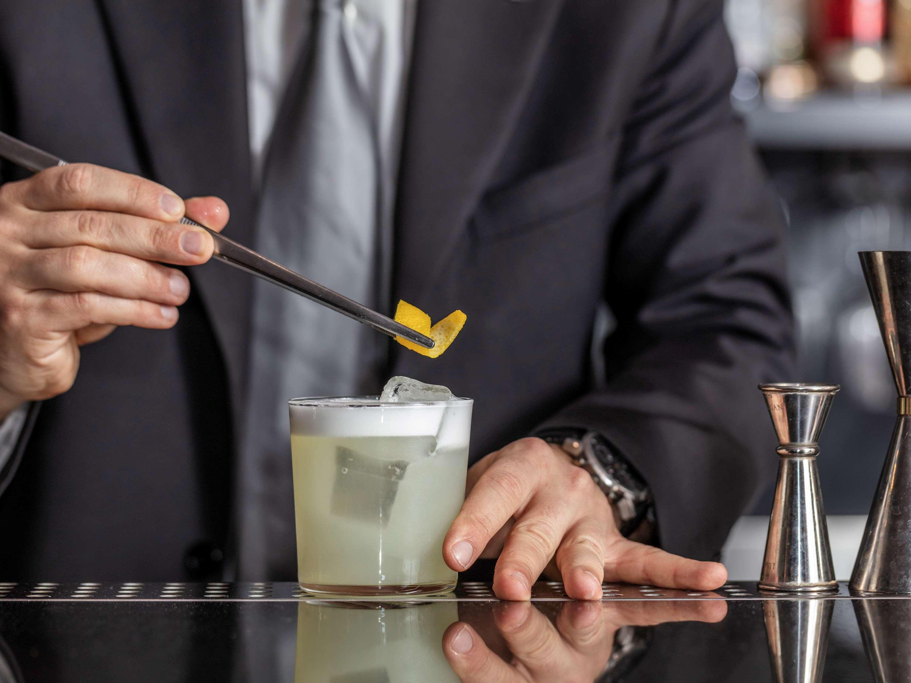 La Griffe Hotel Roma Exteriér fotografie A bartender adding a lemon twist to a cocktail